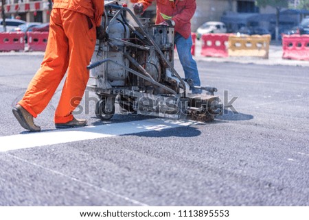 worker working on the asphalt road construction site