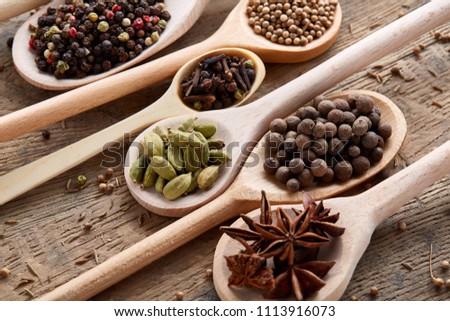 Colourful aromatic various spices for cooking on old wooden board, close-up, flat lay, selective focus.