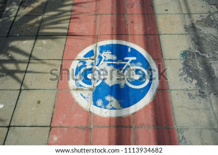 Blue Bicycle Lane sign on the sidewalk                              