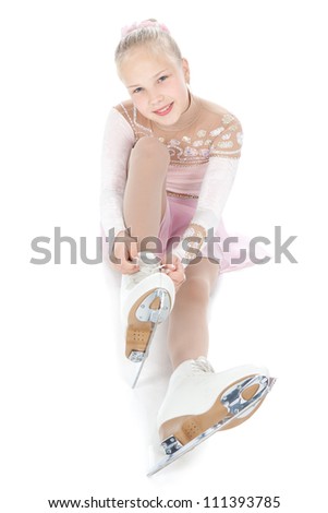 Beautiful young smiling girl in ice skating sitting over white background