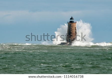 Giant waves cover the stone tower of Whaleback lighthouse in southern Maine during an astronomically high tide. Royalty-Free Stock Photo #1114016738