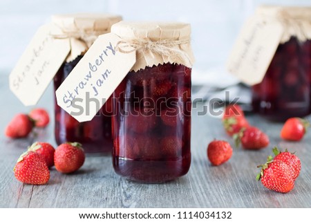 Strawberry jam in glass jar on  gray background. Soft focus.