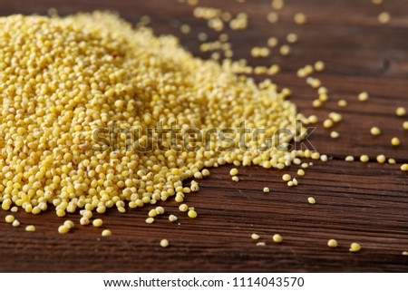 Lentils in a wooden bowl on rustic wooden background, top view, close-up, selective focus.