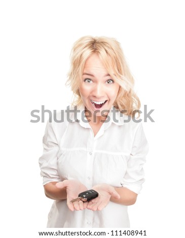 Portrait of pretty surprised young girl holding car key in her hands isolated on white background. Expression of shock, surprise and happiness. Woman got car as present or became winner.