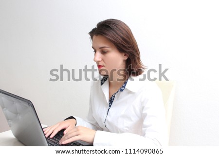 Beautiful young girl working on laptop in office