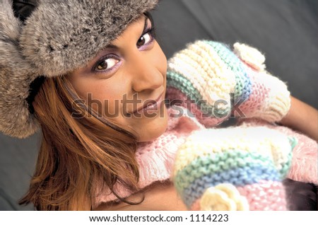 Young woman with brown eyes wearing faux fur hat and knitted mittens