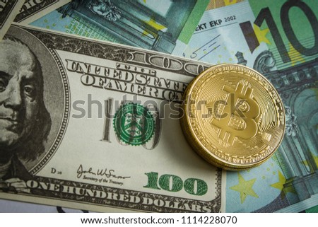Coins in the form of bitcoin on a pile of euro banknotes
