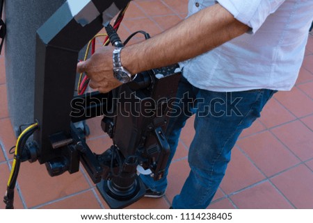 Cameraman checking equipment of camera in broadcast television green screen virtual studio room.