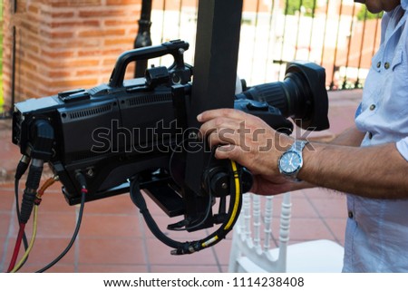 Cameraman checking equipment of camera in broadcast television green screen virtual studio room.
