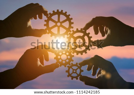 Business concept idea. four hands of businessmen collect a puzzle from gears. Cooperation, teamwork, strategy, creativity, innovation. Royalty-Free Stock Photo #1114242185