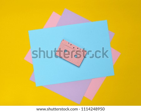 Audio cassette on a pastel-colored paper background. Retro media technology 80s. Music, entertainment. Top view. minimalism trend
