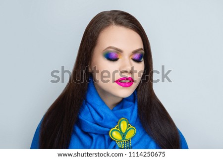 Young lady woman girl with bright make up, multicoloured shadows, crimson lips neon lipstick lip gloss. Colorful glitters. Blue scarf, massive wow brooch handmade of beads, colourful conceptual idea.