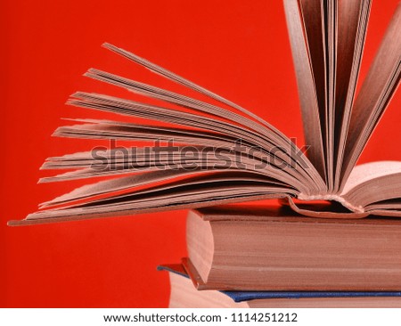 Open book, a stack of books isolated on a red background. Copy space, pastel color trend
