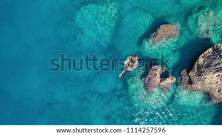 Aerial view at the girl on sea surface. Beautiful composition at the summer time