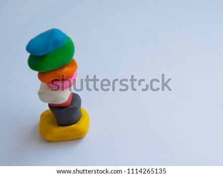 Colorful construction made of small pieces of plasticine isolated on white background. Balance concept. Top view