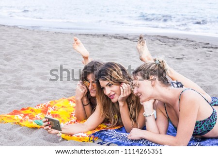 Nice beautiful caucasian girls use smartphone to take picture at the beach during the summer. ocean and natyre in backgorund. lifestyle and happiness concept