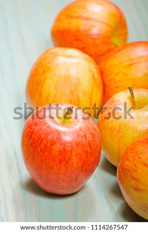 closeup of fresh delicious red apples on a turquoise blue wooden board