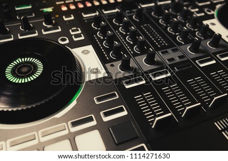 Professional concert dj turntables player device with sound mixer panel & jog wheel.Club disc jockey stage equipment for playing music on party.Digital turn table deck for nightclub performance Royalty-Free Stock Photo #1114271630