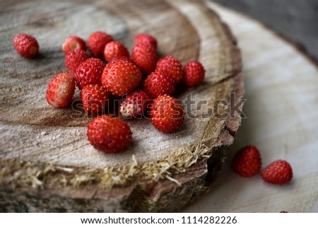
wild strawberries on a wooden stand Royalty-Free Stock Photo #1114282226