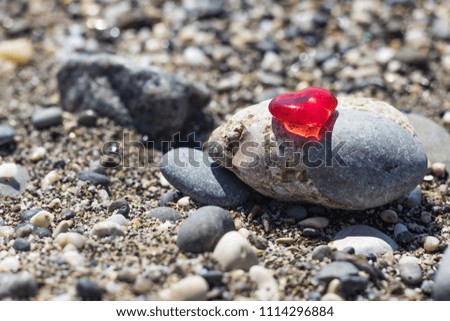 Symbol of the heart on a large pebble shingle on the beach, background