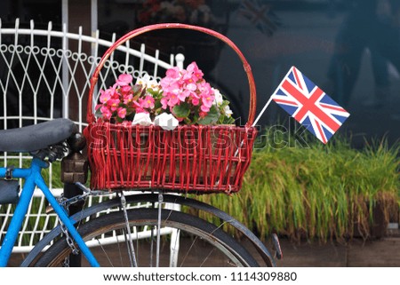 Basket with flowers and English flag on the trunk of the bicycle