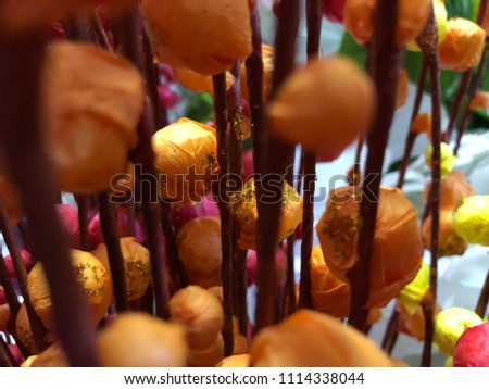 Artificial flowers from corrugated paper. Balls of paper on a stick. Paper stems for registration of holidays. Artificial color willow