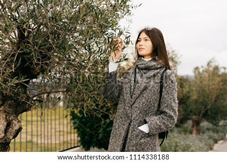 beautiful brunette girl in gray coat walking through city streets, style and fashion