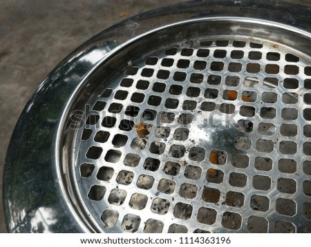 close up street stainless ashtray with cigarette 
