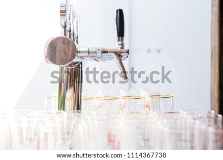 photo of glasses for beer and a beer faucet on the summer terrace