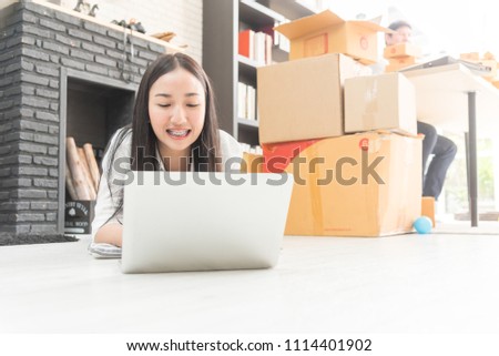 professional young online shopping company team of two co worker with box of products in office background and face to camera. selective focus photo.