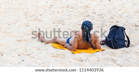 background. man sunbathing on a sandy beach