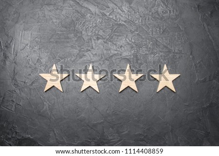 four stars on a dark background. The concept of rating and evaluation. The rating of the hotel, restaurant, mobile application. Quality service, buyer choice. Success in business