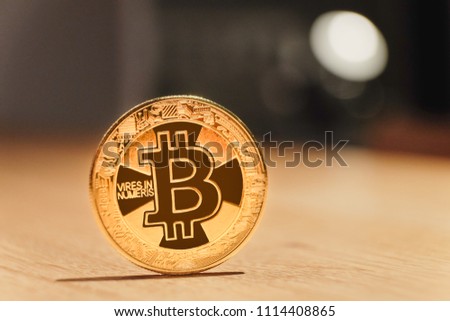 The golden bitcoin on wooden table and bokeh background, golden bitcoin symbol of bitcoin crytocurrency from blockchain technology.