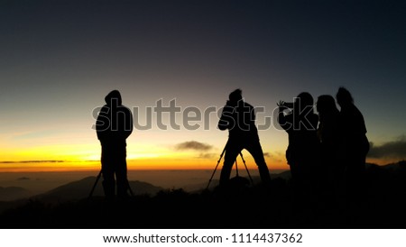 Male and female  photographer taking photos in a beautiful nature setting and watch the beauty of the sunset ,taking pictures of the beautiful moments during the sunset 