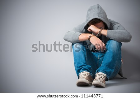 Arrested teenager with handcuffs on his hands Royalty-Free Stock Photo #111443771