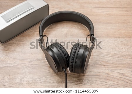 Black headphone,and music player put on wooden foor.