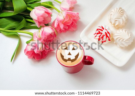 a cup of cappuccino coffee with a picture of a halloween symbol from cinnamon on milk foam