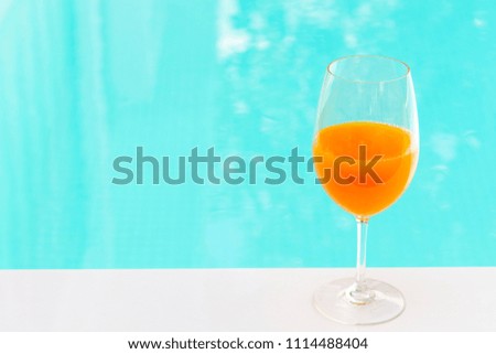 orange juice in wine glass on edge  the blue sky pool in party luxury hotel, thailand