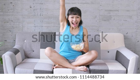 Woman watching the football match with snack