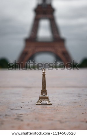 Mini Eiffel Tower with the real Eiffel Tower in the background