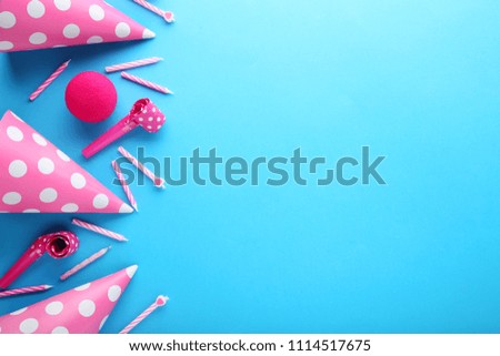 Birthday party caps, blowers and candles on blue background