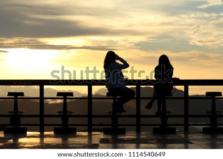 Young woman photographing  at coffee shop of a hill during sunrise.
