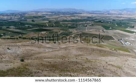 Aerial picture of countryside area Sicily Italy showing the wide landscape some wine farms and grape fields and in background showing the mountains of the typical Sicilian landscape