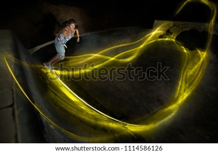 A young white Caucasian skateboarder doing an ollie jump at night