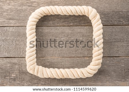Rope frame on wooden background 