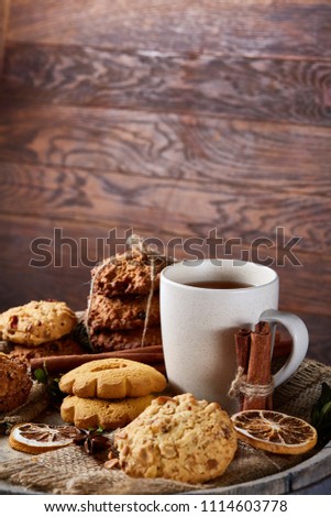 White porcelain mug of tea and sweet cookies on wooden background, top view, selective focus