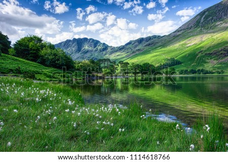 Idyllic landscape of Lake District National Park, Cumbria, Uk.UNESCO world heritage side.Beautiful scenery of mountain valley with  clean lake in spring.Blue sky with few clouds over green hills. Royalty-Free Stock Photo #1114618766
