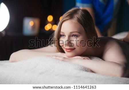 Woman having massage in the spa salon . Professional Massage Therapist doing massage on womans back Royalty-Free Stock Photo #1114641263