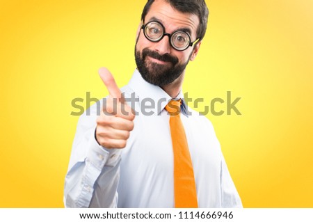 Funny man with glasses with thumb up on colorful background