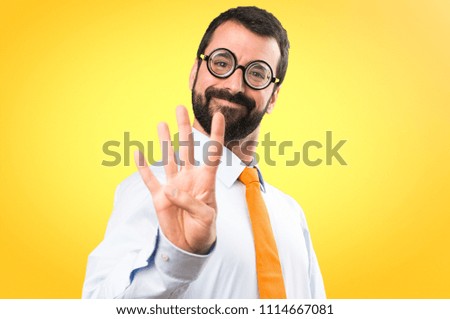 Funny man with glasses counting four on colorful background